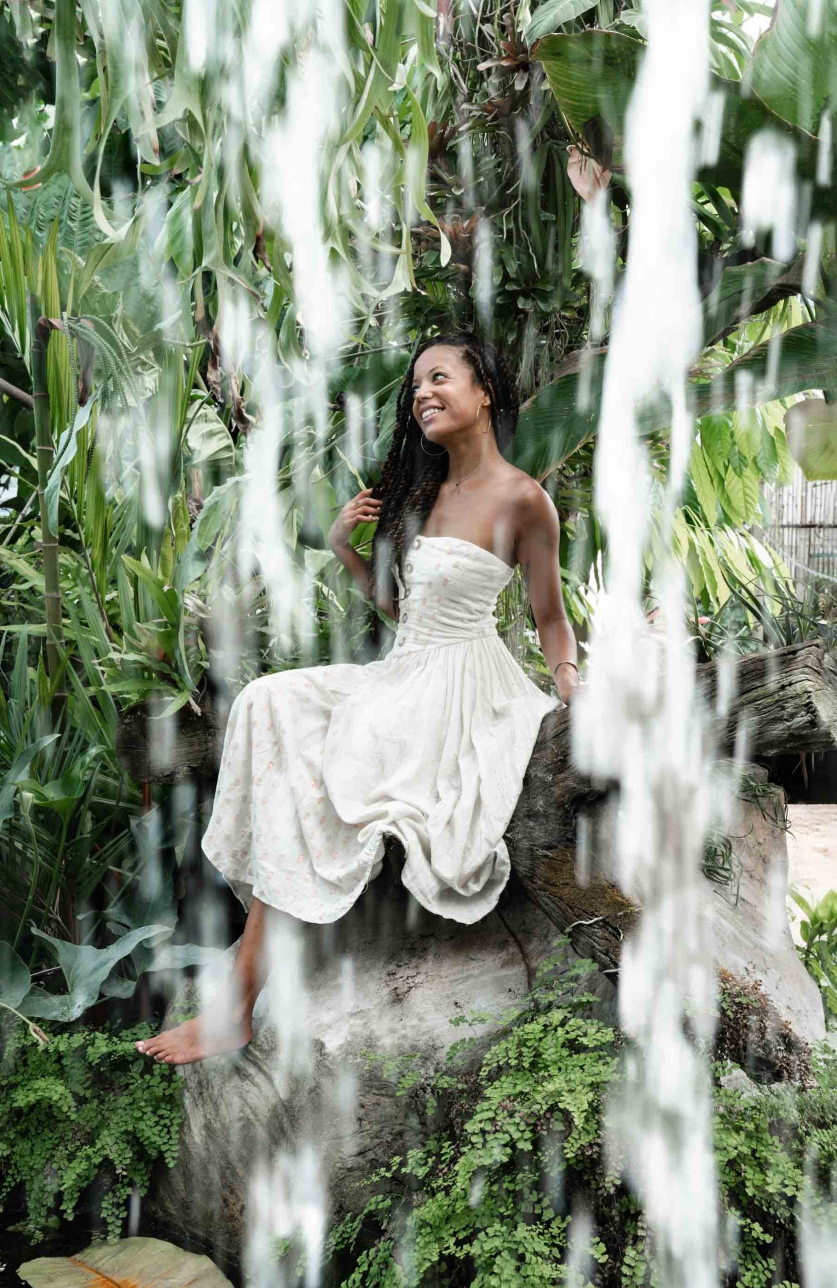 Woman modeling and smiling under waterfall in the New Orleans City Park Botanical Garden