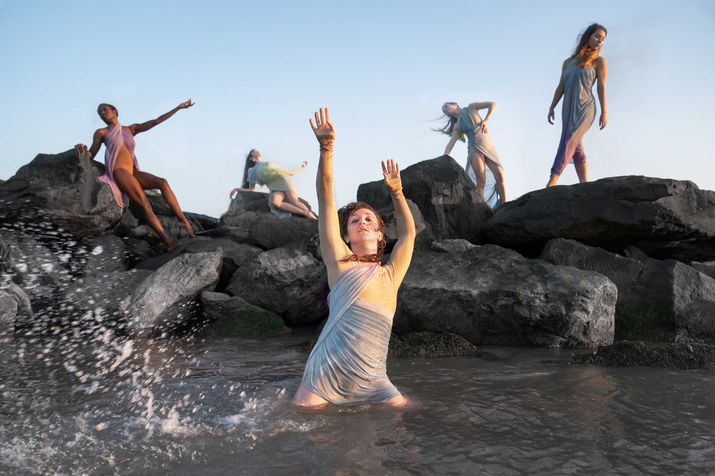 Female dancers posing on beach rocks at sunset along Louisiana Gulf Coast