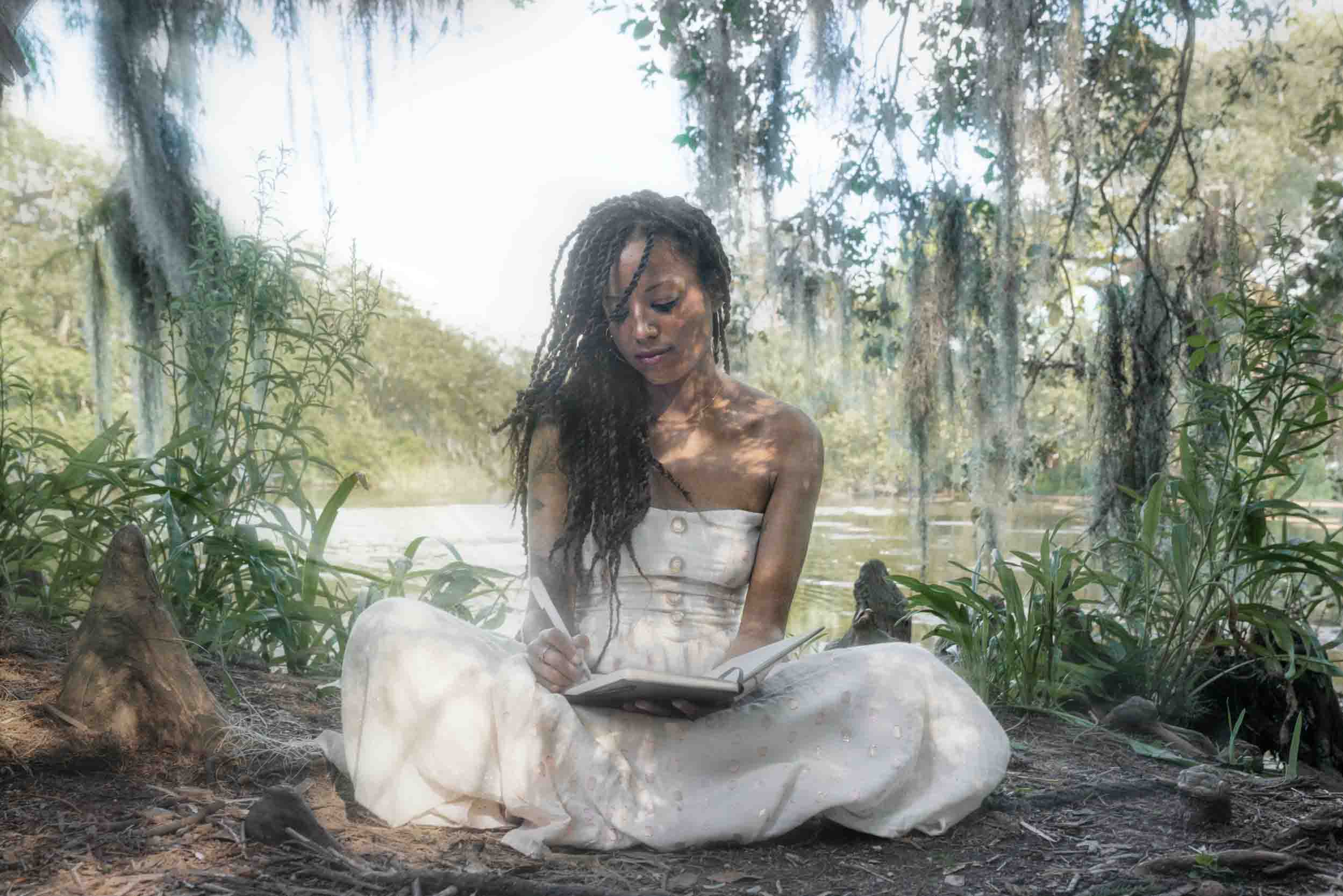 Woman writing in her book under Spanish moss in New Orleans City Park