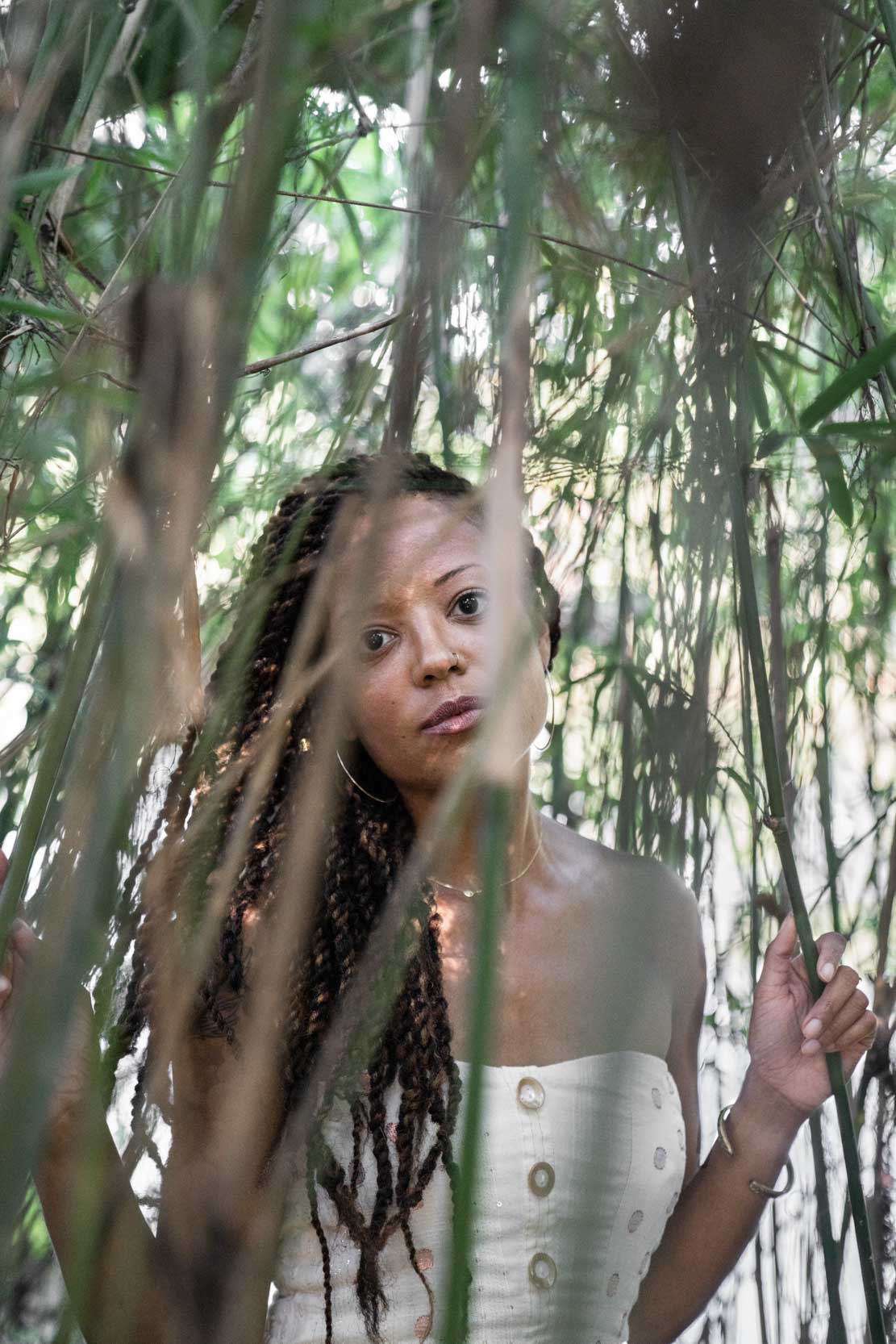 Model looking through leaves with timid expression in New Orleans City Park