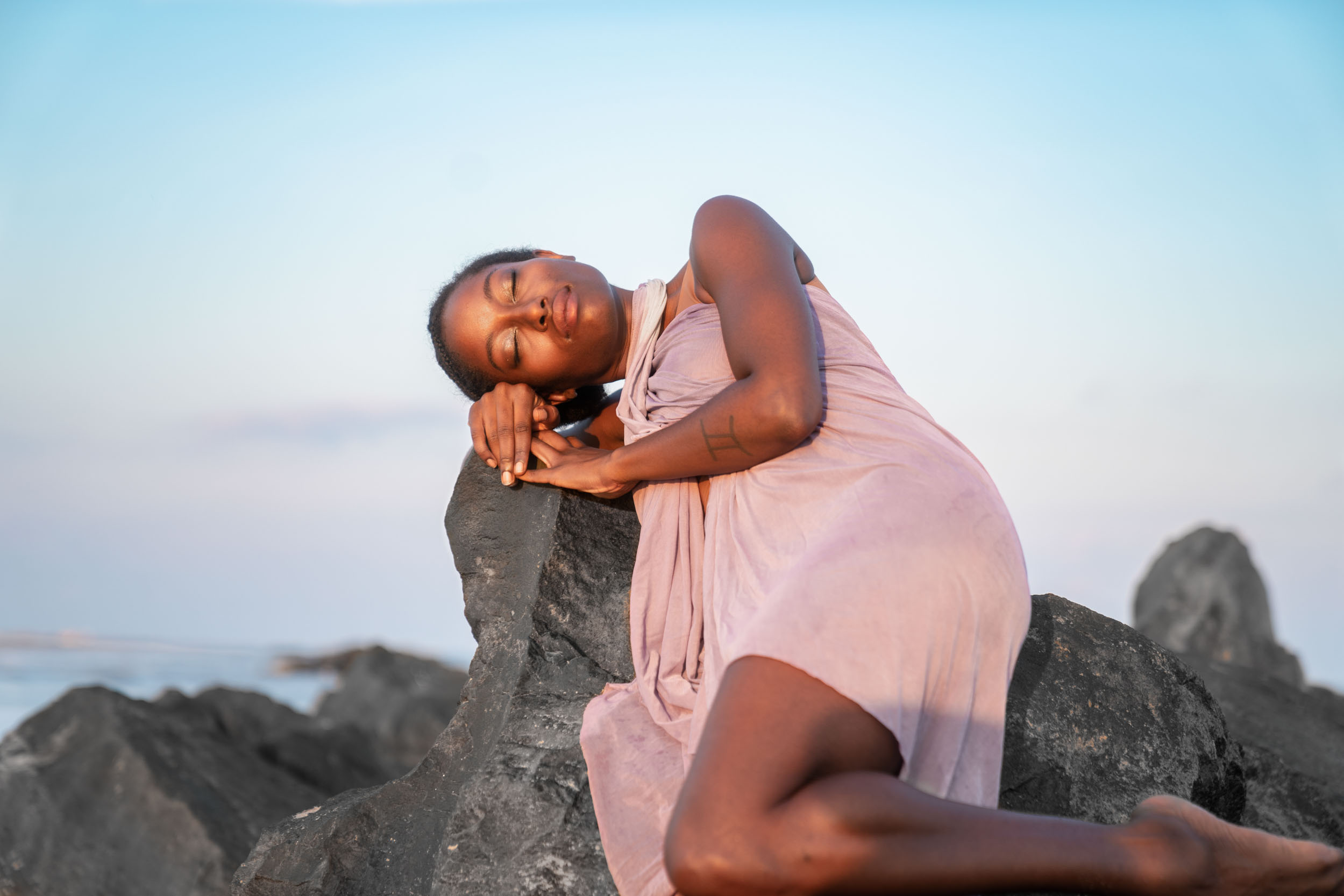 A woman in a beautiful dress sleeping and dreaming on a Louisiana Gulf Coast beach at sunset