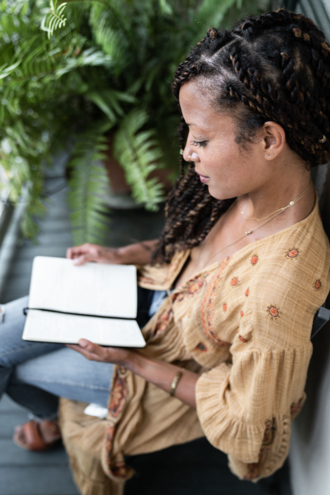 A woman reading and writing on a New Orleans French Quarter balcony